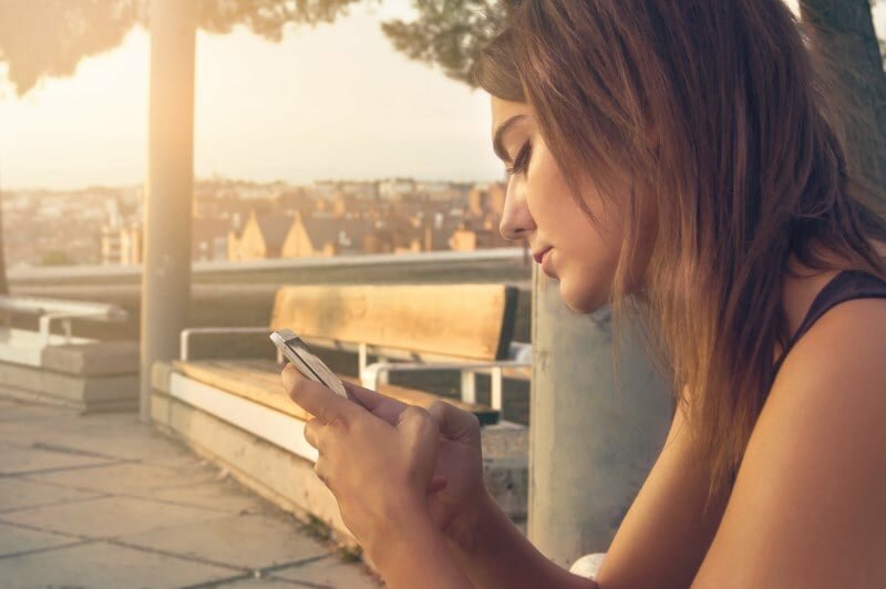 Woman Staring At Phone Confused